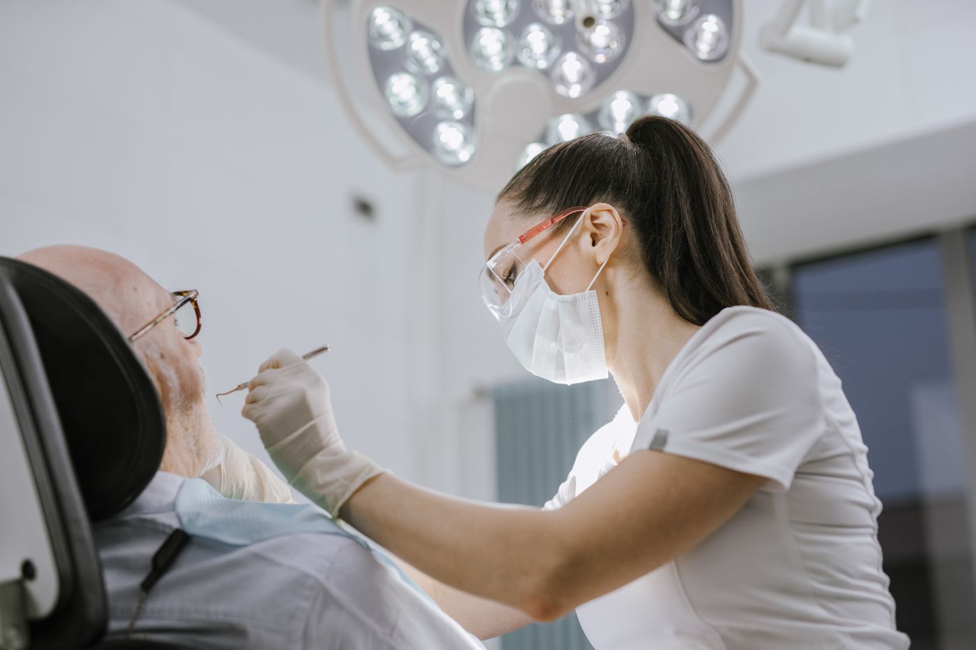 Dentista atendendo uma paciente na cadeira do consultório